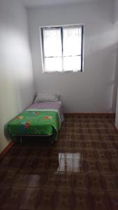 una piccola camera con un letto in una stanza con finestra di Casa Nicola a Rapone