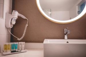 a bathroom with a blow dryer and a mirror at Astral Palma Hotel in Eilat