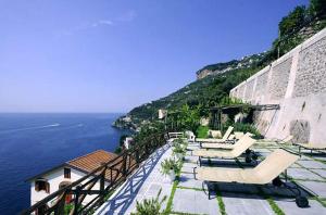 uma varanda com cadeiras e vista para o oceano em Pagliarulo Complex by AMALFIVACATION em Ravello