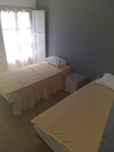 two beds in a room with a window at Buarcos-Figueira de Foz in Figueira da Foz