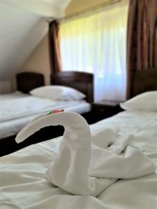 um quarto de hotel com duas camas com lençóis brancos em Casa Muscelelor em Pietroşani