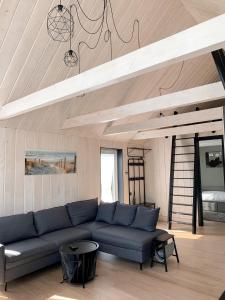 a living room with a blue couch and a ladder at HARMONY Design and Vacation House in Bigauņciems