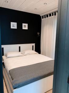 um quarto com uma cama branca e uma parede preta em HARMONY Design and Vacation House em Bigauņciems