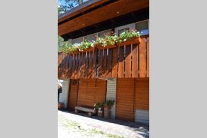 a house with a wooden fence with flower boxes on it at Chalet nel bosco in Borca di Cadore