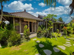 a house with a green lawn in front of it at Villa Alisha Pererenan Canggu in Canggu