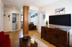 福米加尔Foratata By PIRINEOS360 Formigal - 3 dormitorios Y 2 baños的客厅里有一台平板电视，位于木制娱乐中心