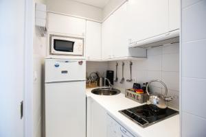 福米加尔Foratata By PIRINEOS360 Formigal - 3 dormitorios Y 2 baños的带水槽和冰箱的白色厨房