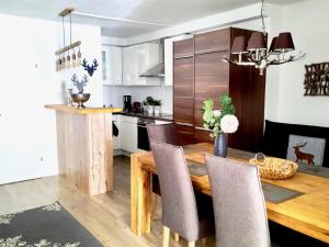 uma cozinha e sala de jantar com uma mesa de madeira e cadeiras em BELLE KITZ PURE im Zentrum by Belle Stay em Kitzbühel