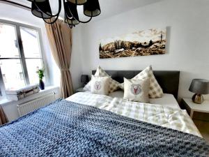um quarto com uma cama azul e branca com almofadas em BELLE KITZ PURE im Zentrum by Belle Stay em Kitzbühel
