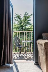 a balcony with a chair and a table on a porch at The Westleton Crown in Westleton