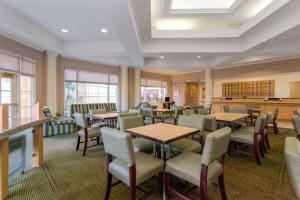 a dining room with tables and chairs and windows at La Quinta by Wyndham Lakeland West in Lakeland