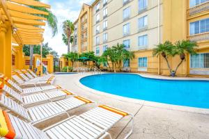 a hotel with a swimming pool and lounge chairs at La Quinta by Wyndham Lakeland West in Lakeland