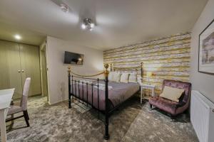a bedroom with a bed and a wooden wall at The Westleton Crown in Westleton