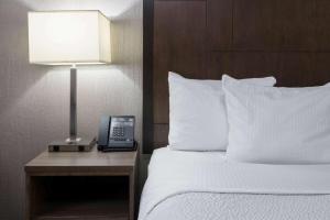 a hotel room with a bed with a lamp and a phone at La Quinta by Wyndham Fairbanks Airport in Fairbanks