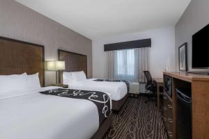 a hotel room with two beds and a flat screen tv at La Quinta by Wyndham Fairbanks Airport in Fairbanks