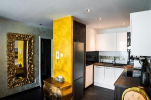 a kitchen with white cabinets and a gold mirror at AH Luxury Galerka in Košice