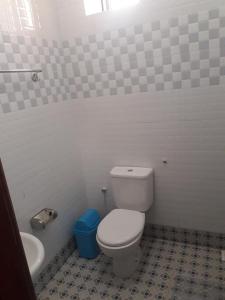 a bathroom with a white toilet and a sink at Kyato Hotel in Kasanda