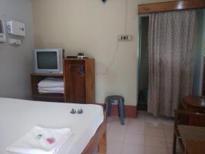 a bathroom with a bath tub and a television at Tarangamala Resort in Mandarmoni