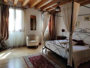 a bedroom with a canopy bed and a chair at Alberghiera Venezia in Venice