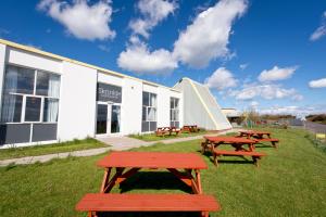 a group of picnic tables in front of a building at YHA Manorbier in Tenby