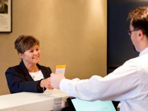 a man and a woman sitting at a table shaking hands at ibis Stevenage Centre in Stevenage