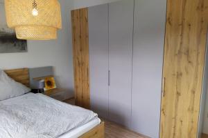 een slaapkamer met een bed en een kroonluchter bij Entspannen im Grünen, Ferienwohnung mit eigenem Garten in Keilberg