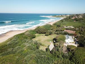 an aerial view of a beach with a house and the ocean at Umzumbe Surf House in Umzumbe