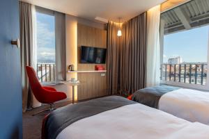 Cette chambre comprend deux lits et une grande fenêtre. dans l'établissement Holiday Inn Express - Ljubljana, an IHG Hotel, à Ljubljana