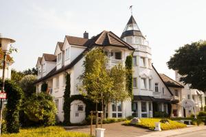 ein großes weißes Haus mit einem Turm in der Unterkunft Ferienanlage Duhnen Haus 19 in Cuxhaven