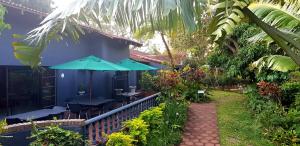 una casa con patio attrezzato con tavoli e ombrelloni di Santa Lucia Guest House a St Lucia