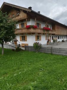 a building with flowers on the balconies and a yard at Wiesenhof in Fügen