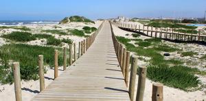 a wooden boardwalk on the beach near the ocean at Hotel Monte Lírio in Espinho