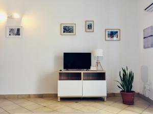 soggiorno con TV su un armadietto bianco di La Dimora della Cattedrale a Palermo