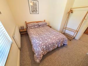 a bedroom with a bed with a comforter on it at Bassett Flat with 2 Double Bedrooms and Superfast Wi-Fi in Sittingbourne