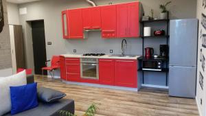 a kitchen with red cabinets and a stainless steel refrigerator at Street Art Apartment in Oświęcim