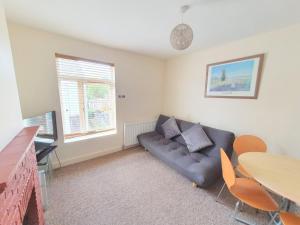 a living room with a couch and a table at Bassett Flat with 2 Double Bedrooms and Superfast Wi-Fi in Sittingbourne