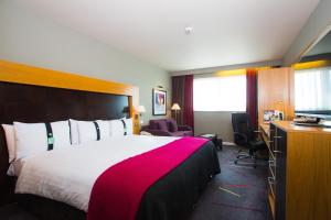 een hotelkamer met een groot bed en een televisie bij Holiday Inn Aberdeen West, an IHG Hotel in Westhill 