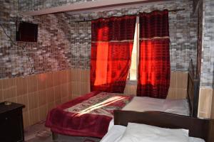 マリーにあるMusyari Guest Houseのベッドルーム1室(ベッド2台付)、赤いカーテン付きの窓が備わります。