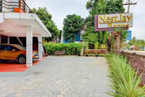 a restaurant with a car parked in a parking lot at Nestlay Rooms Vanagaram in Chennai