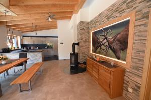 a living room with a large painting of a deer on a brick wall at Ferienhaus-Heckelmann Diefenbach in Diefenbach