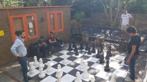 un grupo de personas de pie alrededor de un tablero de ajedrez gigante en The Arcade Hotel Amsterdam, en Ámsterdam