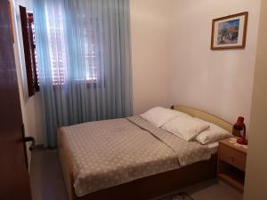 um pequeno quarto com uma cama e uma janela em Queen beach apartments Nin Sabunike - Green street I em Nin