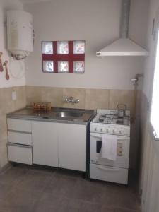 una pequeña cocina con fogones y fregadero en Departamento Amoblado en Villa María