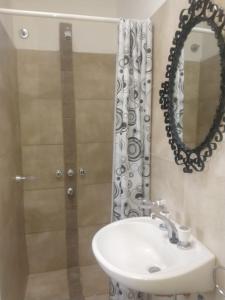ein Badezimmer mit Waschbecken, Spiegel und Dusche in der Unterkunft Departamento Amoblado in Villa María