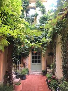 een voordeur van een huis met bomen en planten bij Le Patio d'Arles in Arles