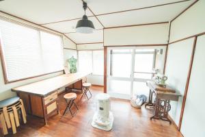 a room with a desk and some chairs and windows at Guesthouse NUI okhotsk #NU1 in Abashiri