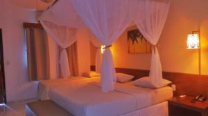 1 dormitorio con 2 camas con cortinas blancas en Delta Park Hotel, en Parnaíba