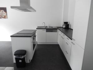 a kitchen with white cabinets and a black counter top at Haus Stadler in Irsch