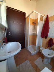 uma casa de banho com um lavatório, um chuveiro e um WC. em Vacanze da Macandu & Stefi em San Giovanni Suergiu