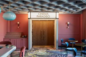 a restaurant with pink walls and a wooden door at PURO Łódź Centrum in Łódź